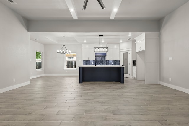3813 Galvez Ave, Fort Worth, TX 76111 - kitchen featuring open floor plan, backsplash, white cabinetry, light wood-style flooring, and a chandelier