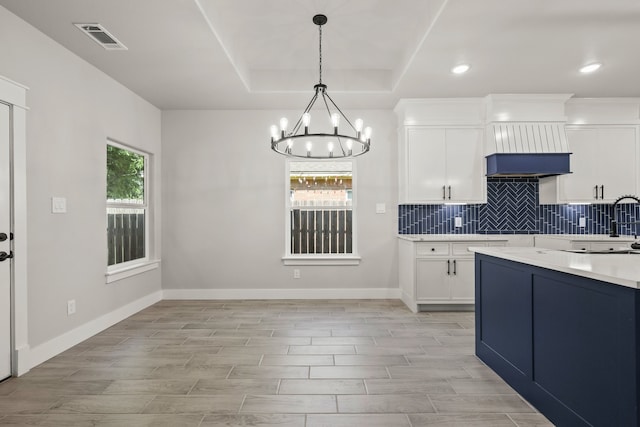 3813 Galvez Ave, Fort Worth, TX 76111 - kitchen with a chandelier, light countertops, wood tiled floors, tasteful backsplash, and recessed lighting