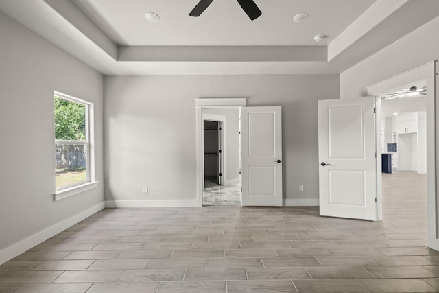 3813 Galvez Ave, Fort Worth, TX 76111 - unfurnished bedroom featuring baseboards, wood finish floors, and a tray ceiling