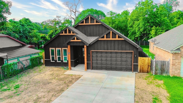 3813 Galvez Ave, Fort Worth, TX 76111 - view of front of house featuring an attached garage, driveway, and board and batten siding