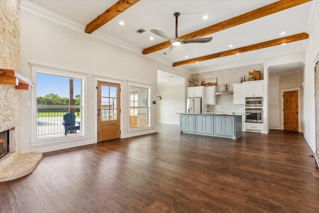 203 Bold Springs Ct, West, TX 76691 - unfurnished living room with a stone fireplace, beamed ceiling, a ceiling fan, dark wood-type flooring, and a sink