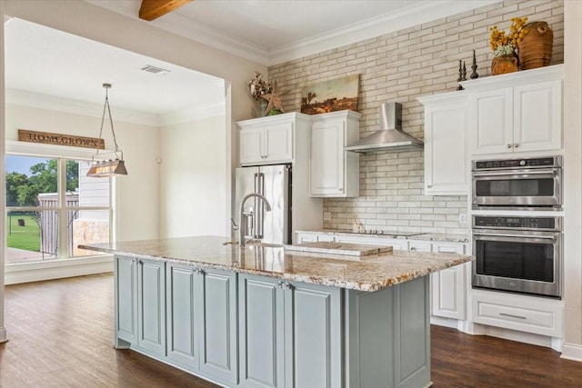 203 Bold Springs Ct, West, TX 76691 - kitchen with wall chimney range hood, stainless steel appliances, white cabinets, backsplash, and ornamental molding