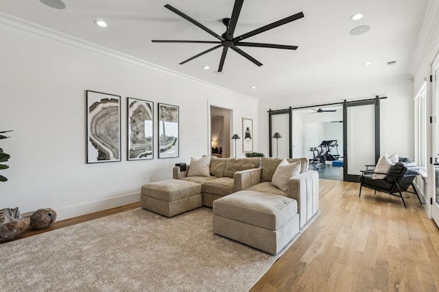 4309 American Pharoah Way, Celina, TX 75009 - living room featuring a barn door, light wood-type flooring, a ceiling fan, ornamental molding, and recessed lighting
