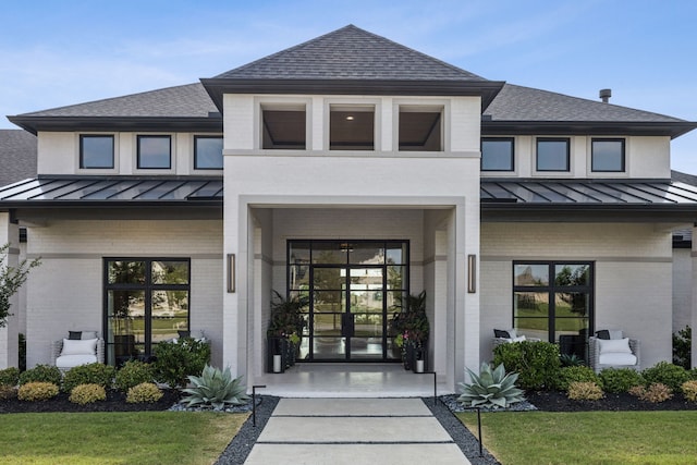 4309 American Pharoah Way, Celina, TX 75009 - view of exterior entry featuring a standing seam roof, brick siding, a shingled roof, and metal roof
