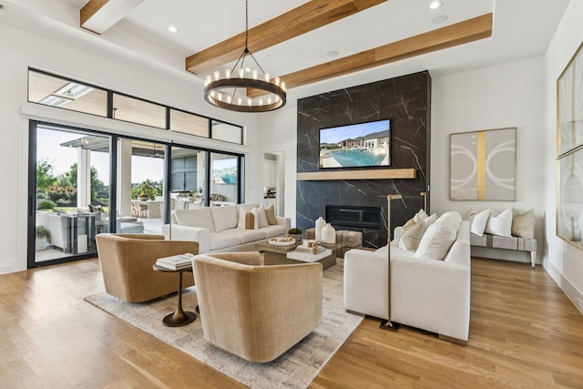 4309 American Pharoah Way, Celina, TX 75009 - living area featuring wood finished floors, recessed lighting, beam ceiling, a fireplace, and a chandelier