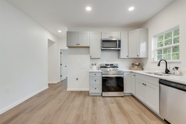 1113 Verbena St, Fort Worth, TX 76104 - kitchen with stainless steel appliances, a sink, light wood-style flooring, recessed lighting, and light countertops