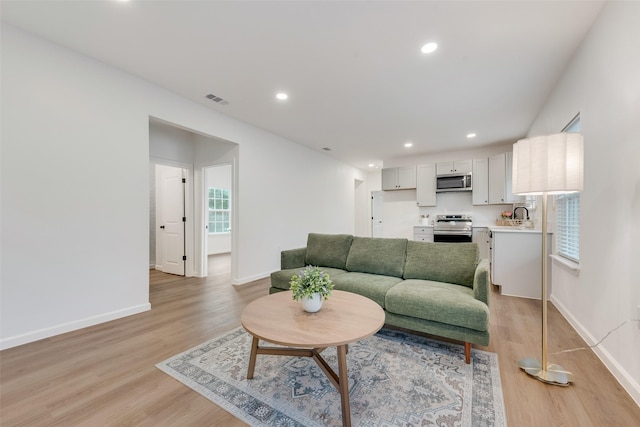 1113 Verbena St, Fort Worth, TX 76104 - living room featuring light wood-type flooring, baseboards, and recessed lighting