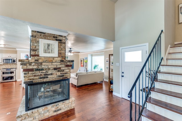 606 Kirby Ln, Richardson, TX 75080 - living area with stairway, a ceiling fan, wood finished floors, crown molding, and baseboards