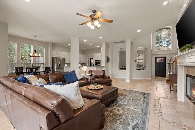 4013 Tulane St, Flower Mound, TX 75022 - living room featuring a tiled fireplace, a ceiling fan, a chandelier, light tile patterned floors, and healthy amount of natural light