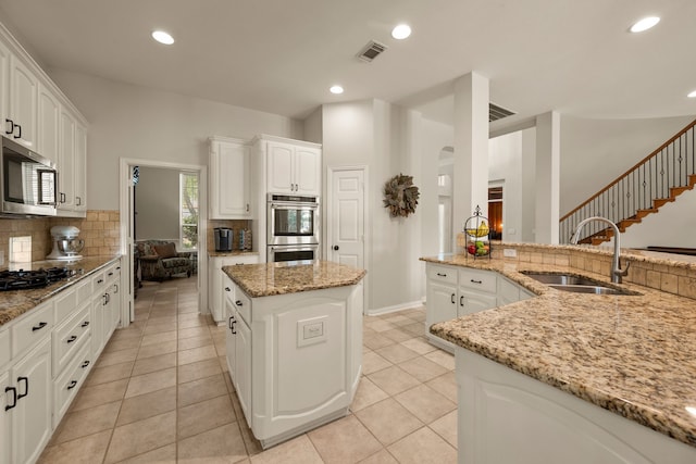 4013 Tulane St, Flower Mound, TX 75022 - kitchen featuring a sink, stainless steel appliances, decorative backsplash, light stone countertops, and white cabinetry