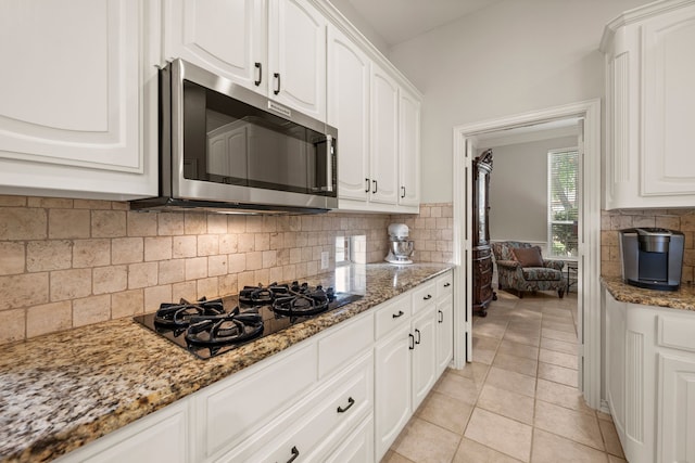 4013 Tulane St, Flower Mound, TX 75022 - kitchen with stainless steel microwave, black gas stovetop, white cabinets, and light stone countertops