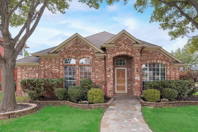 5644 Overland Dr, The Colony, TX 75056 - traditional home featuring brick siding, a front yard, and a shingled roof