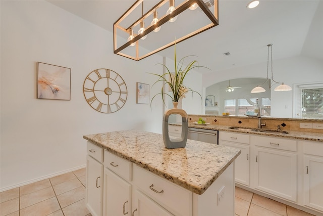 5644 Overland Dr, The Colony, TX 75056 - kitchen featuring a sink, vaulted ceiling, a kitchen island, light stone counters, and hanging light fixtures
