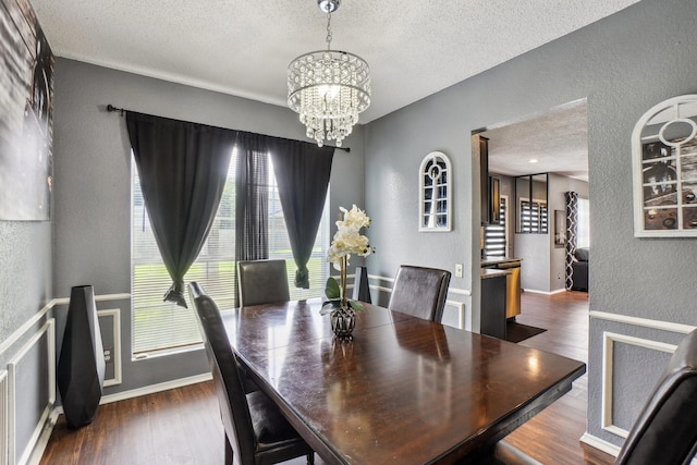 3017 Deanne Ct, Fort Worth, TX 76123 - dining area with a textured wall, a textured ceiling, a chandelier, wood finished floors, and healthy amount of natural light