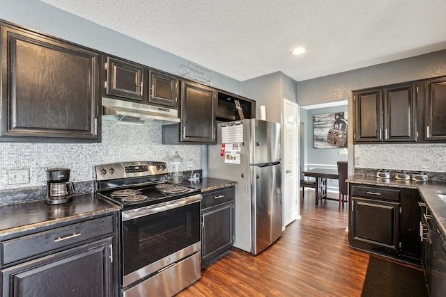 3017 Deanne Ct, Fort Worth, TX 76123 - kitchen featuring appliances with stainless steel finishes, under cabinet range hood, dark countertops, backsplash, and a textured ceiling