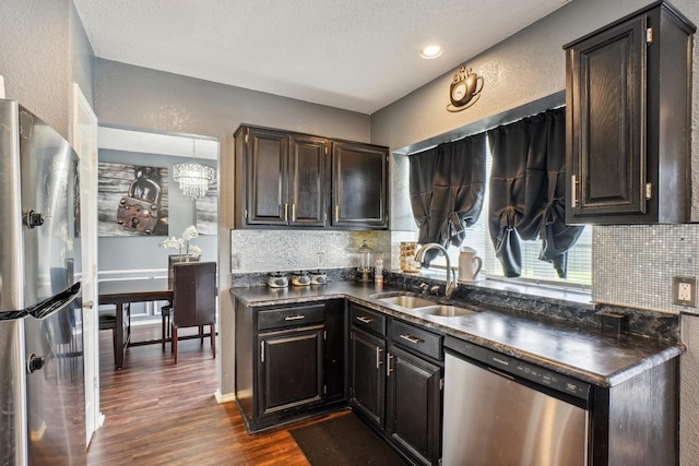 3017 Deanne Ct, Fort Worth, TX 76123 - kitchen with stainless steel appliances, a sink, dark countertops, tasteful backsplash, and a textured wall