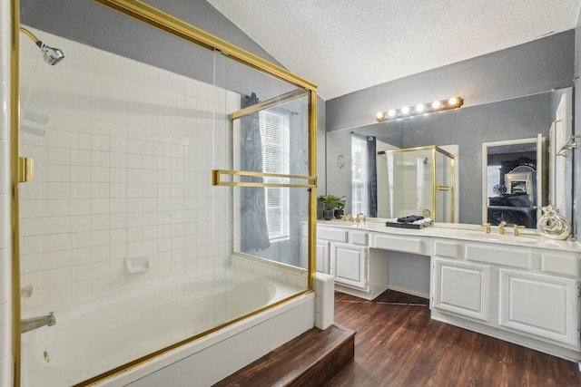 3017 Deanne Ct, Fort Worth, TX 76123 - bathroom with double vanity, vaulted ceiling, wood finished floors, enclosed tub / shower combo, and a textured ceiling