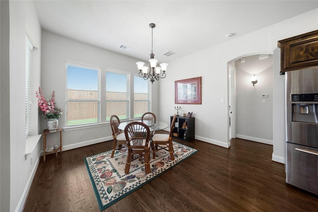 8670 Soto Ln, Frisco, TX 75036 - dining area with arched walkways, dark wood-type flooring, a chandelier, and baseboards