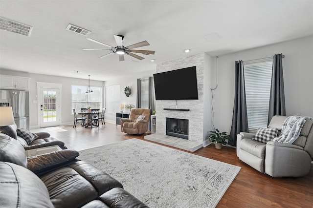 3752 Menard Dr, Carrollton, TX 75010 - living area with ceiling fan, dark wood-style flooring, a stone fireplace, recessed lighting, and baseboards
