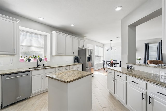 3752 Menard Dr, Carrollton, TX 75010 - kitchen featuring appliances with stainless steel finishes, a sink, white cabinets, recessed lighting, and light stone countertops
