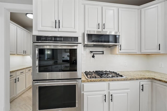 3752 Menard Dr, Carrollton, TX 75010 - kitchen featuring stainless steel appliances, white cabinetry, backsplash, and light stone countertops