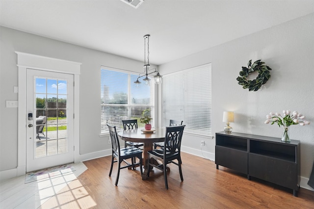 3752 Menard Dr, Carrollton, TX 75010 - dining room featuring a chandelier, wood finished floors, and baseboards