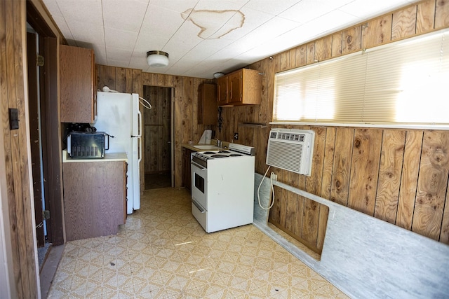 1109 Sayles Blvd, Abilene, TX 79605 - kitchen with white appliances, light floors, a wall unit AC, wooden walls, and a sink