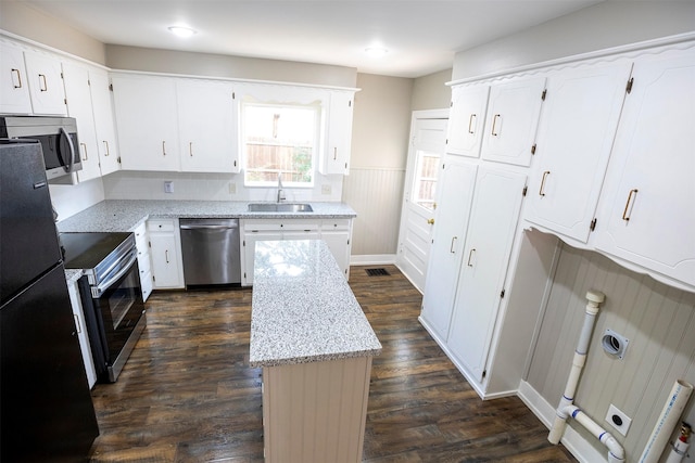 1109 Sayles Blvd, Abilene, TX 79605 - kitchen with stainless steel appliances, a kitchen island, a sink, dark wood-type flooring, and light stone counters