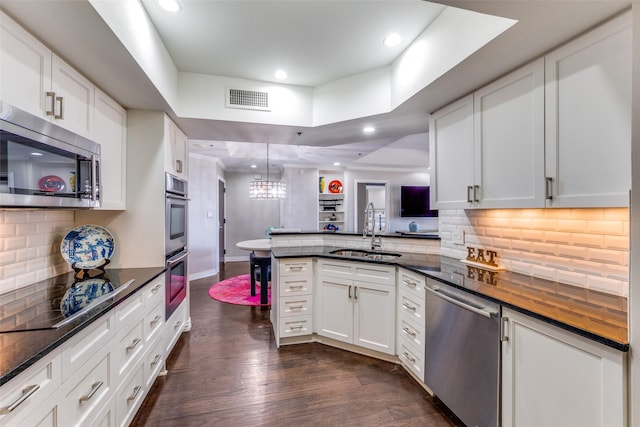 5909 Luther Ln Unit 900, Dallas, TX 75225 - kitchen featuring stainless steel appliances, a sink, a peninsula, dark wood-style floors, and recessed lighting