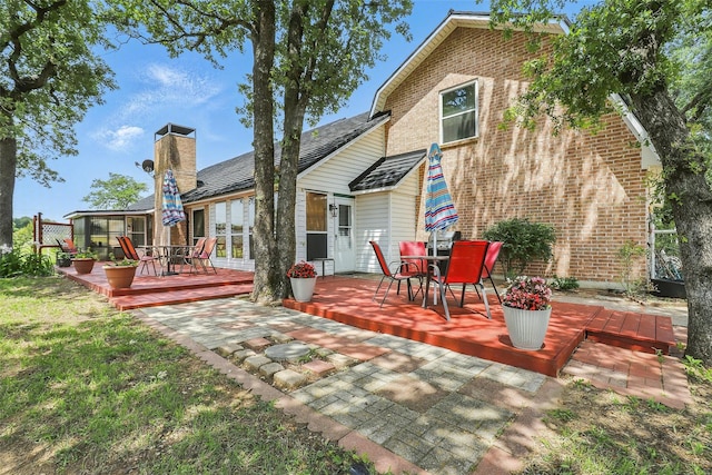 9816 County Road 603c, Burleson, TX 76028 - rear view of house with outdoor dining space, a deck, brick siding, and a lawn