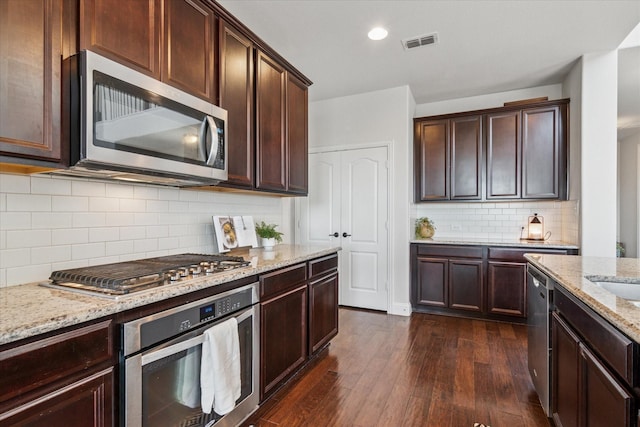 1029 Spring Falls Dr, Mckinney, TX 75071 - kitchen featuring stainless steel appliances, dark wood-type flooring, light stone counters, dark brown cabinetry, and recessed lighting