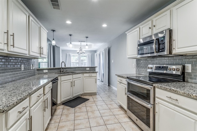 1611 N College St, Mckinney, TX 75069 - kitchen featuring appliances with stainless steel finishes, a sink, a peninsula, white cabinetry, and recessed lighting
