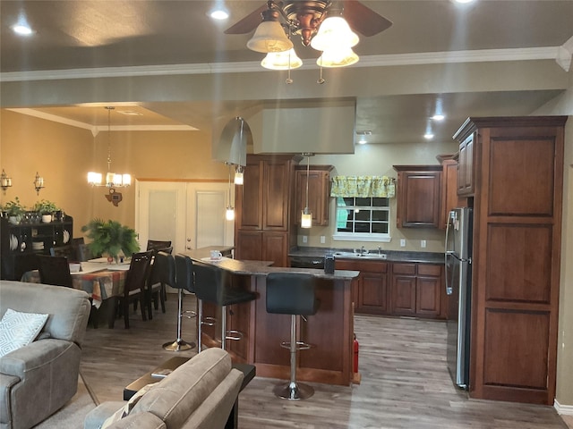 322 Farm Rd Unit 2283, Clarksville, TX 75426 - kitchen with freestanding refrigerator, light wood-style flooring, a ceiling fan, a breakfast bar, and crown molding