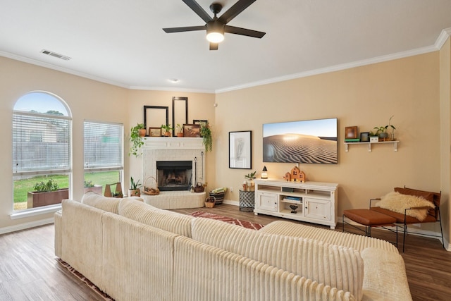 2408 Buffalo Run, Burleson, TX 76028 - living area featuring wood finished floors, ceiling fan, crown molding, a tiled fireplace, and baseboards