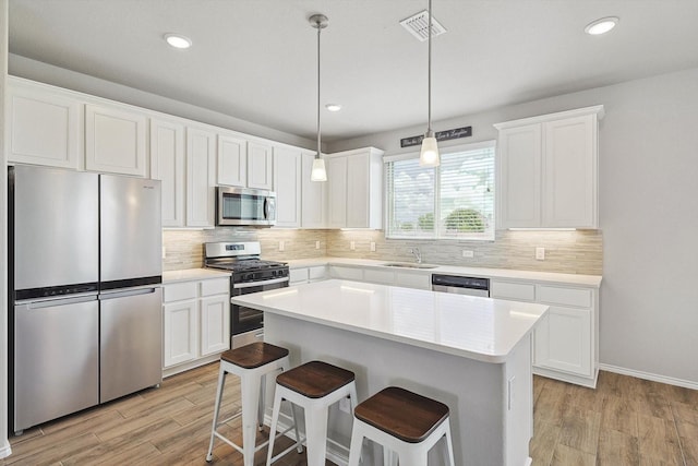 1608 Star Fleet Dr, Haslet, TX 76052 - kitchen featuring stainless steel appliances, light wood-style floors, a breakfast bar area, a kitchen island, and recessed lighting