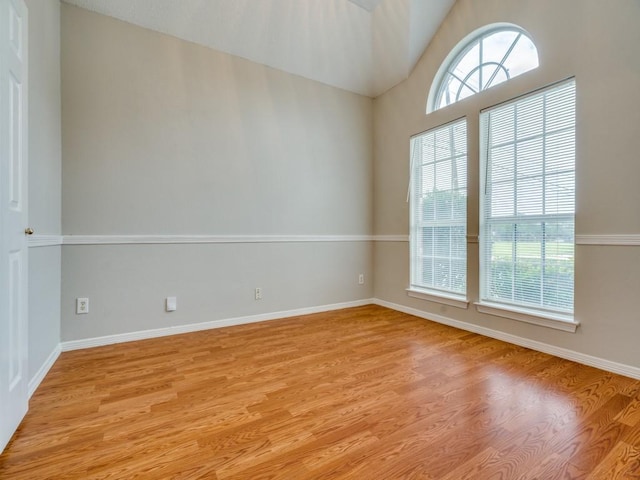 18851 Park Grove Ln, Dallas, TX 75287 - spare room with light wood-style flooring, baseboards, and lofted ceiling