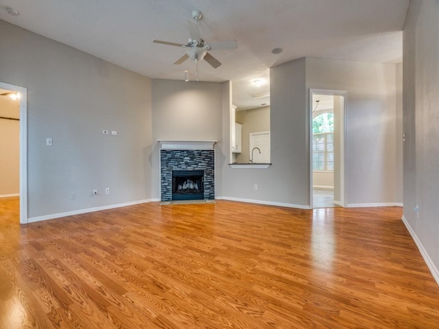 18851 Park Grove Ln, Dallas, TX 75287 - unfurnished living room with a ceiling fan, light wood-style flooring, baseboards, and a fireplace