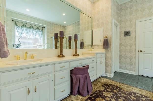 2909 Harkness Dr, Plano, TX 75093 - bathroom with double vanity, wallpapered walls, tile patterned flooring, and baseboards