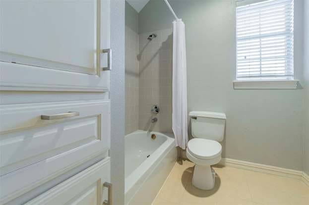2909 Harkness Dr, Plano, TX 75093 - full bathroom with toilet, shower / tub combo with curtain, baseboards, tile patterned floors, and vanity