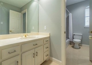 2909 Harkness Dr, Plano, TX 75093 - bathroom featuring vanity, toilet, shower / bath combo, and baseboards