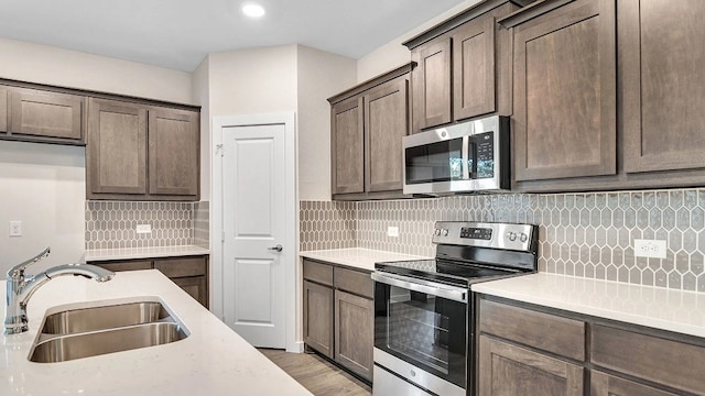 1524 Latimer Ct, Trenton, TX 75490 - kitchen featuring stainless steel appliances, a sink, light countertops, decorative backsplash, and dark brown cabinets
