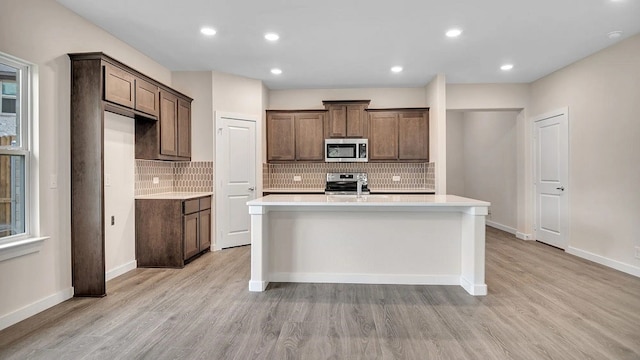 1524 Latimer Ct, Trenton, TX 75490 - kitchen featuring stainless steel appliances, light wood-style flooring, an island with sink, light countertops, and recessed lighting