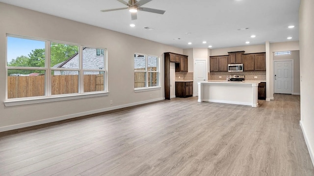 1524 Latimer Ct, Trenton, TX 75490 - kitchen featuring stainless steel microwave, stove, decorative backsplash, plenty of natural light, and recessed lighting