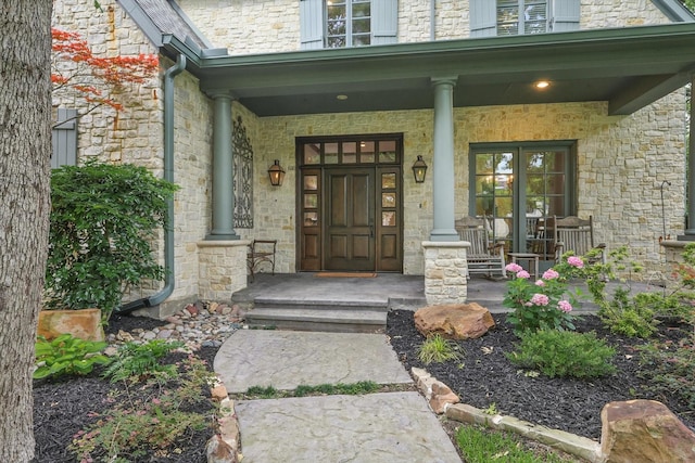 129 Shady Dale Ln, Coppell, TX 75019 - view of exterior entry with stone siding, a porch, and a high end roof