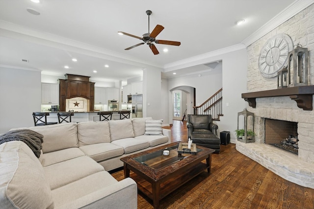 129 Shady Dale Ln, Coppell, TX 75019 - living room featuring a ceiling fan, arched walkways, dark wood-style flooring, a stone fireplace, and recessed lighting