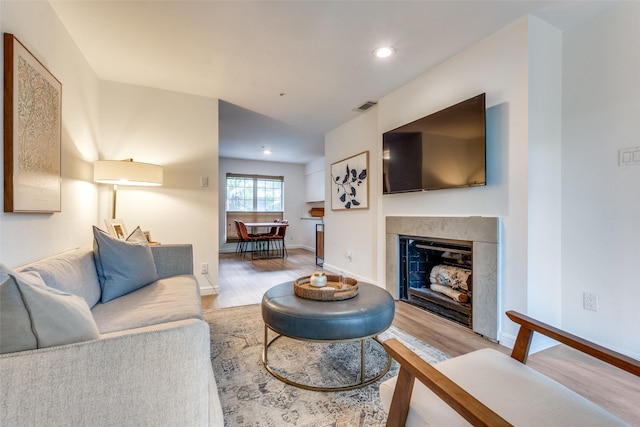 4303 Buena Vista St Unit 206, Dallas, TX 75205 - living room featuring light wood-style flooring, baseboards, a fireplace, and recessed lighting