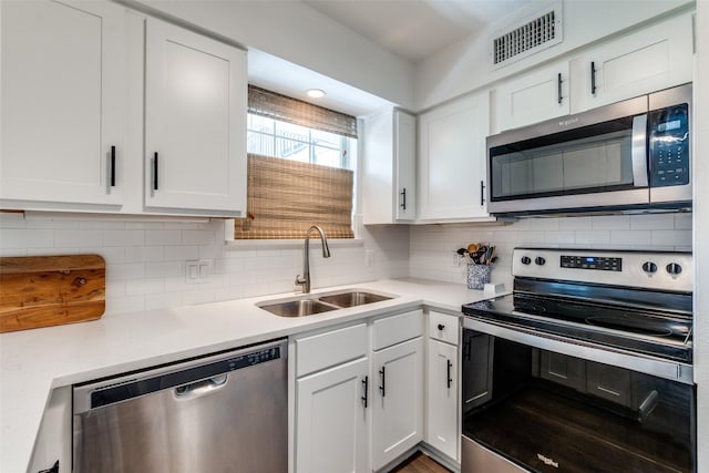 4303 Buena Vista St Unit 206, Dallas, TX 75205 - kitchen with stainless steel appliances, a sink, light countertops, and white cabinetry