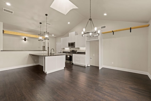 407 Charleston Park Dr, Woodway, TX 76712 - kitchen with stainless steel appliances, dark countertops, a sink, a chandelier, and a skylight