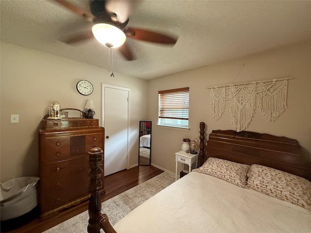 504 Cedar St, Mineral Wells, TX 76067 - bedroom featuring a textured ceiling, dark wood-type flooring, a ceiling fan, and baseboards