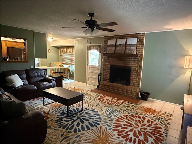 504 Cedar St, Mineral Wells, TX 76067 - living room with a ceiling fan, a textured ceiling, a fireplace, and tile patterned flooring